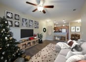 Thumbnail 14 of 14 - a living room with a christmas tree and a ceiling fan