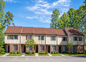 Thumbnail 2 of 3 - Apartment building with a parking lot in front.