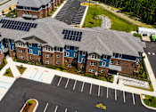 Thumbnail 3 of 7 - A parking lot in front of a building with solar panels on the roof.