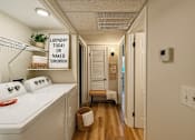 Thumbnail 10 of 40 - Laundry sign in a hallway with a washer and dryer.