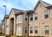 Thumbnail 1 of 15 - A large stone and siding house with a grey roof.
