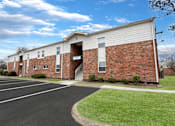 Thumbnail 25 of 25 - A parking lot is in front of a brick building.