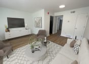 Thumbnail 2 of 31 - a living room with white walls and a large flat screen tv on the wall at The Courts Midtown, Memphis, TN
