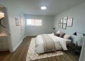 Thumbnail 3 of 31 - a bedroom with a bed and a bathroom in the background at The Courts Midtown, Memphis, TN, 38104