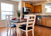 Thumbnail 29 of 33 - a kitchen and dining room with a table and chairs