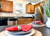 Thumbnail 28 of 33 - a kitchen with stainless steel appliances and a table with plates and napkins on it