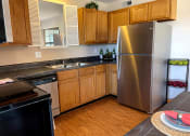 Thumbnail 27 of 33 - a kitchen with stainless steel appliances and wooden cabinets