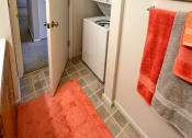 Thumbnail 26 of 33 - the laundry room has a washer and dryer and a door to the bathroom