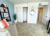 Thumbnail 21 of 33 - a living room with a couch and a hallway with a closet