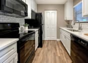 Thumbnail 13 of 38 - a kitchen with white cabinets and black appliances