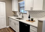 Thumbnail 10 of 38 - a kitchen with white cabinets and a sink and a window
