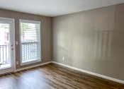 Thumbnail 20 of 38 - an empty living room with wood floors and a door to a balcony