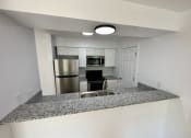 Thumbnail 10 of 14 - a kitchen with granite counter tops and stainless steel appliances at Mammoth at the Orchard Apartments, Rogers, 72756  