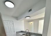 Thumbnail 9 of 14 - a kitchen with a sink and a dishwasher at Mammoth at the Orchard Apartments, Rogers, AR  