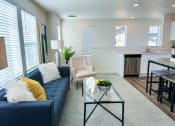 Thumbnail 14 of 65 - a living room with a blue couch and a glass coffee table
