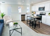 Thumbnail 16 of 65 - a living room with a kitchen and a table with chairs
