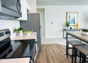 Thumbnail 29 of 65 - a kitchen and dining room with stainless steel appliances and a wooden floor