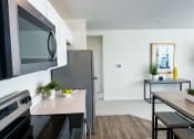 Thumbnail 44 of 65 - a kitchen with stainless steel appliances and a kitchen table with a microwave and a refrigerator