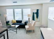 Thumbnail 22 of 65 - a living room with a navy blue couch and white chairs