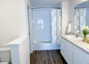 Thumbnail 48 of 65 - a bathroom with a shower and a sink and a toilet