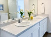 Thumbnail 53 of 65 - a white bathroom with two sinks and a mirror