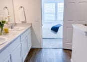 Thumbnail 31 of 65 - a bathroom with two sinks and a door to a bedroom