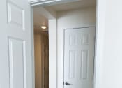 Thumbnail 57 of 65 - an open door into a hallway with white doors and a carpeted floor