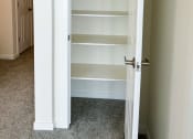 Thumbnail 38 of 65 - a closet with white shelves and a white door