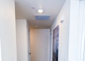 Thumbnail 25 of 65 - a hallway with white walls and a carpeted floor and a white ceiling fan