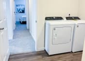Thumbnail 43 of 65 - a white washer and dryer in a room with a hallway and a bedroom