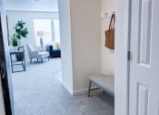 Thumbnail 60 of 65 - a hallway with a bench and a living room with couches and a table