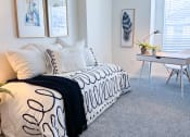Thumbnail 1 of 65 - a bedroom with a bed with black and white pillows and a desk