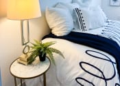 Thumbnail 2 of 65 - a bedroom with a bed and a table with a lamp and pictures on the wall
