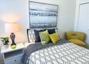 Thumbnail 12 of 65 - a bedroom with a bed and a yellow chair and a white and black bedspread