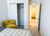 Thumbnail 33 of 65 - a bedroom with a closet and a bed and a yellow arm chair