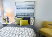 Thumbnail 4 of 65 - a bedroom with a bed and a yellow chair