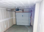 Thumbnail 58 of 65 - a garage with white walls and a gray floor and a garage door