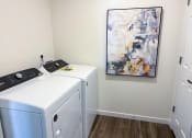 Thumbnail 42 of 65 - a laundry room with two washers and a painting on the wall
