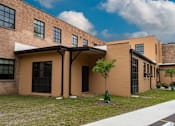 Thumbnail 2 of 17 - A building with a brown facade and a white awning.