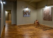 Thumbnail 16 of 17 - A room with wooden floors and two paintings on the wall.