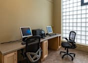 Thumbnail 8 of 17 - Two black chairs sit in front of a desk with two computers.