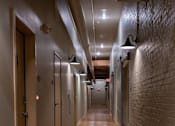 Thumbnail 14 of 25 - A long hallway with wood floors and brick walls.