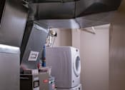 Thumbnail 17 of 25 - A washing machine and dryer in a small room.