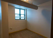 Thumbnail 18 of 25 - A room with a window and a carpeted floor.