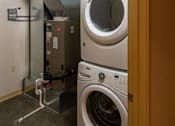Thumbnail 25 of 25 - A view of a laundry room with a washer and dryer stacked on top of each other.
