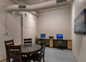 Thumbnail 3 of 25 - A room with a table, chairs, and computers.