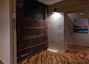 Thumbnail 6 of 25 - A room with a wooden floor and a white wall with a painting hanging on it.