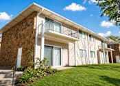 Thumbnail 1 of 7 - A building with a balcony and a stone wall.