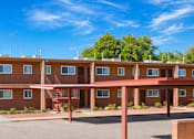 Thumbnail 8 of 8 - Apartment complex with brown buildings and a clear blue sky.