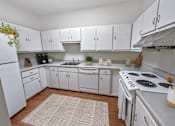 Thumbnail 4 of 12 - A kitchen with white cabinets and appliances.